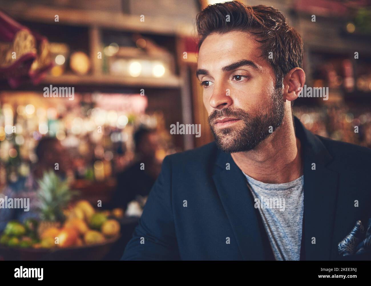 Getting away from it all. a young man sitting in a bar Stock Photo - Alamy
