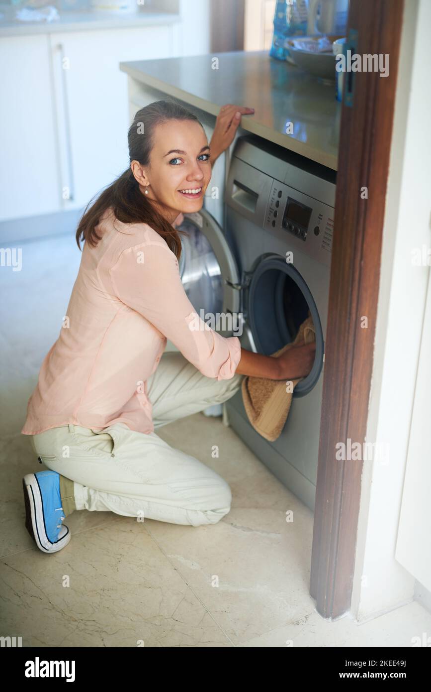 Time to get some laundry done. Portrait of a young woman using a