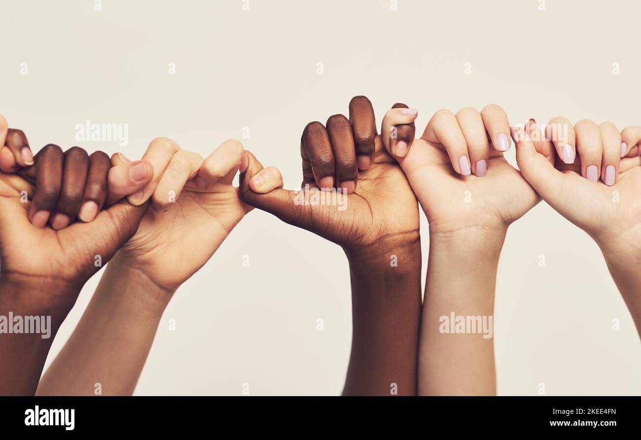Were stronger together. a group of unrecognizable people holding one anothers thumbs in a single line. Stock Photo