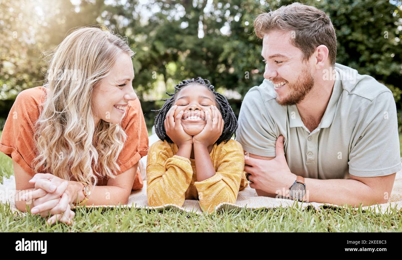 Family, diversity and children with foster parents and adopted daughter together in a park during summer. Kids, love and adoption with a mother Stock Photo