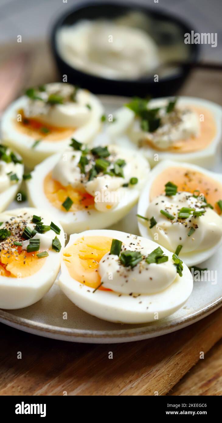 Boiled egg halves with mayonnaise and green onions. Stock Photo