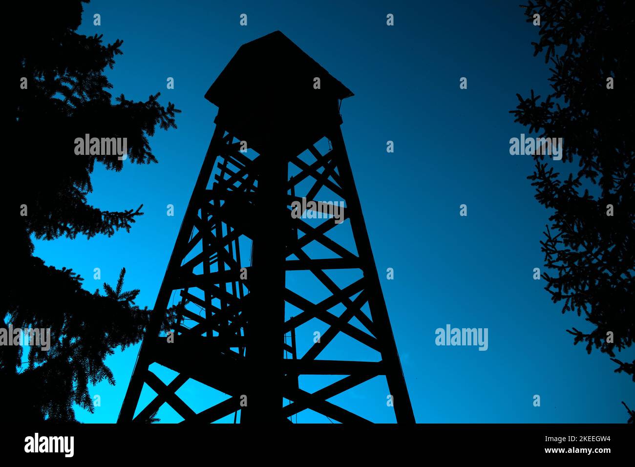 A silhouette of an old watch tower in a rural area in blue sky ...
