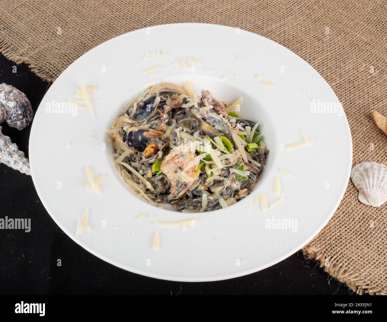 A close-up shot of squid ink pasta with shrimp and scallops Stock Photo