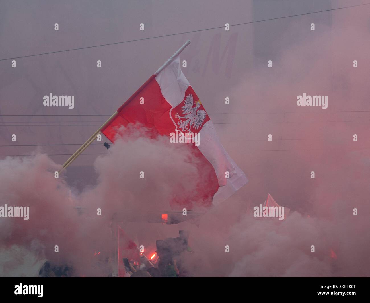 Polish banner shrouded in smoke. Independence day, Poland, 11.11.2022. Independence march. Stock Photo