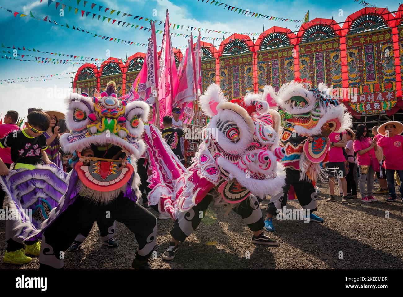 Lion dancers perform with their elaborate, colourful puppets at the decennial Da Jiu festival site, Kam Tin, New Territories, Hong Kong, 2015 Stock Photo