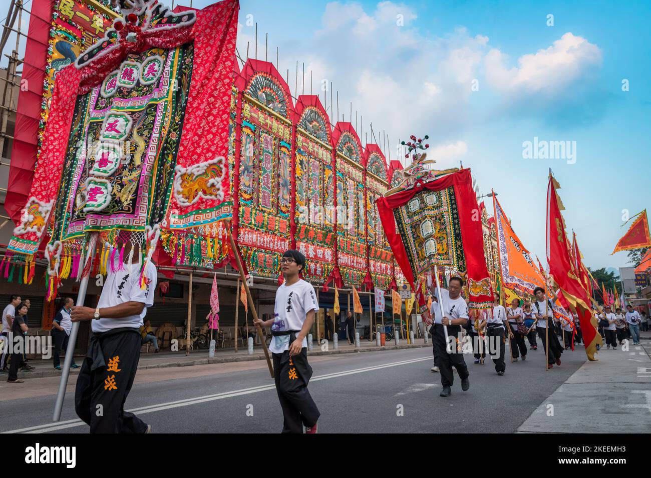 Villagers carry elaborate, colourful banners in a procession on the main street of Kam Tin village at the decennial Da Jiu festival, Hong Kong, 2015 Stock Photo