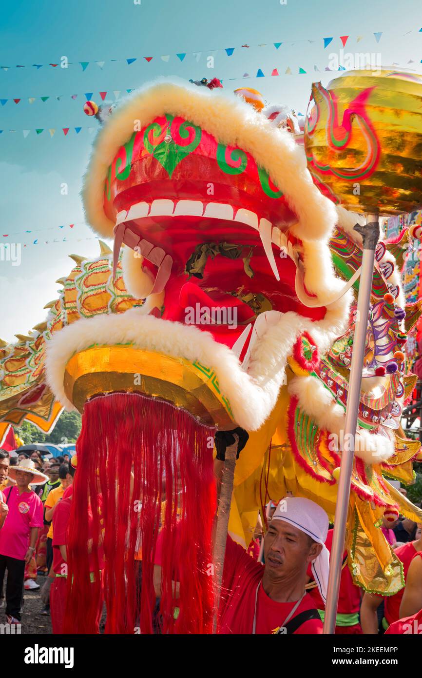 The strain of carrying the heavy head shows on the face of a dragon dance team member at the decennial Da Jiu festival site, Kam Tin, Hong Kong, 2015 Stock Photo