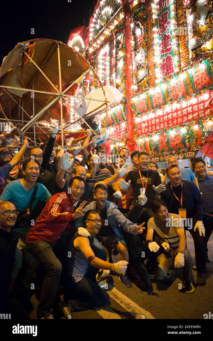 Villagers pose for photos with the effigy of the Ghost King in the street in Kam Tin at night during the decennial Da Jiu festival, Hong Kong, 2015 Stock Photo