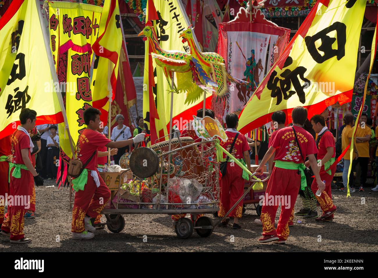 Dragon dance team members pull a cart with a ceremonial drum, gong, and pennants  at the decennial Da Jiu festival site, Kam Tin, Hong Kong, 2015 Stock Photo