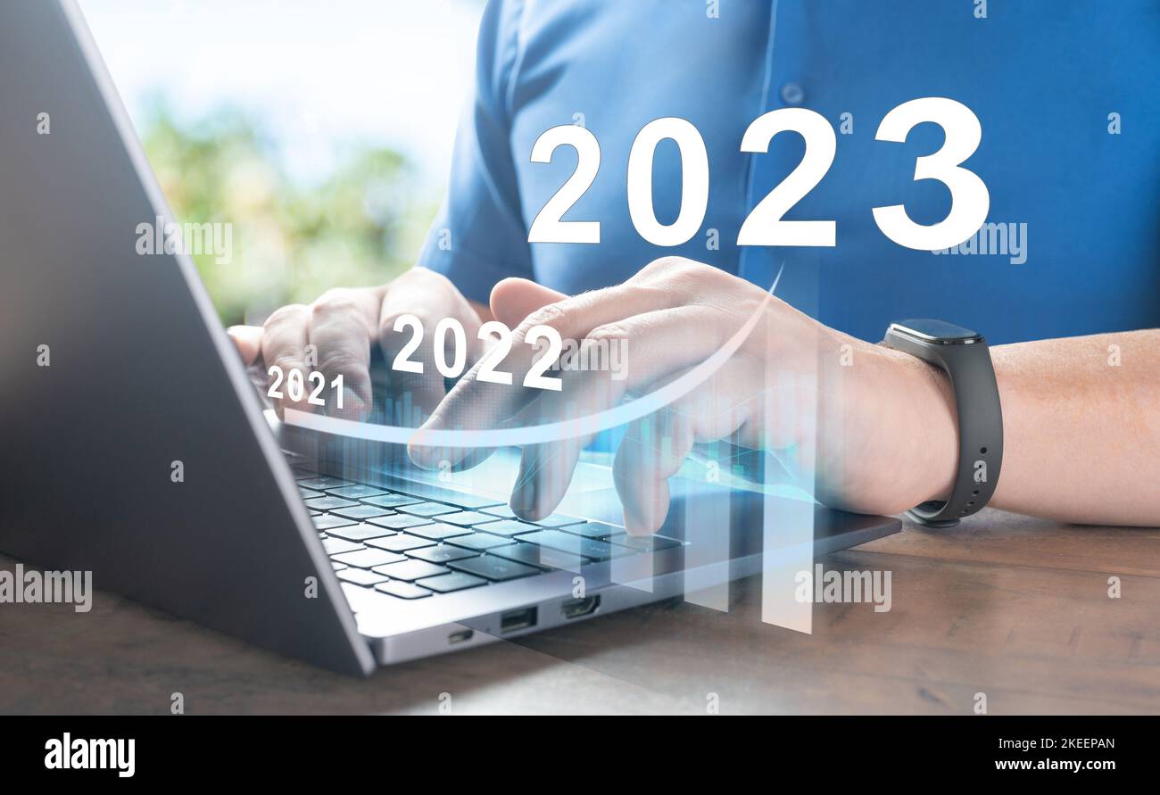 2023 new year. Business success and investment growth in 2023 years. man hand using laptop computer with virtual growth graph chart diagram, stock mar Stock Photo