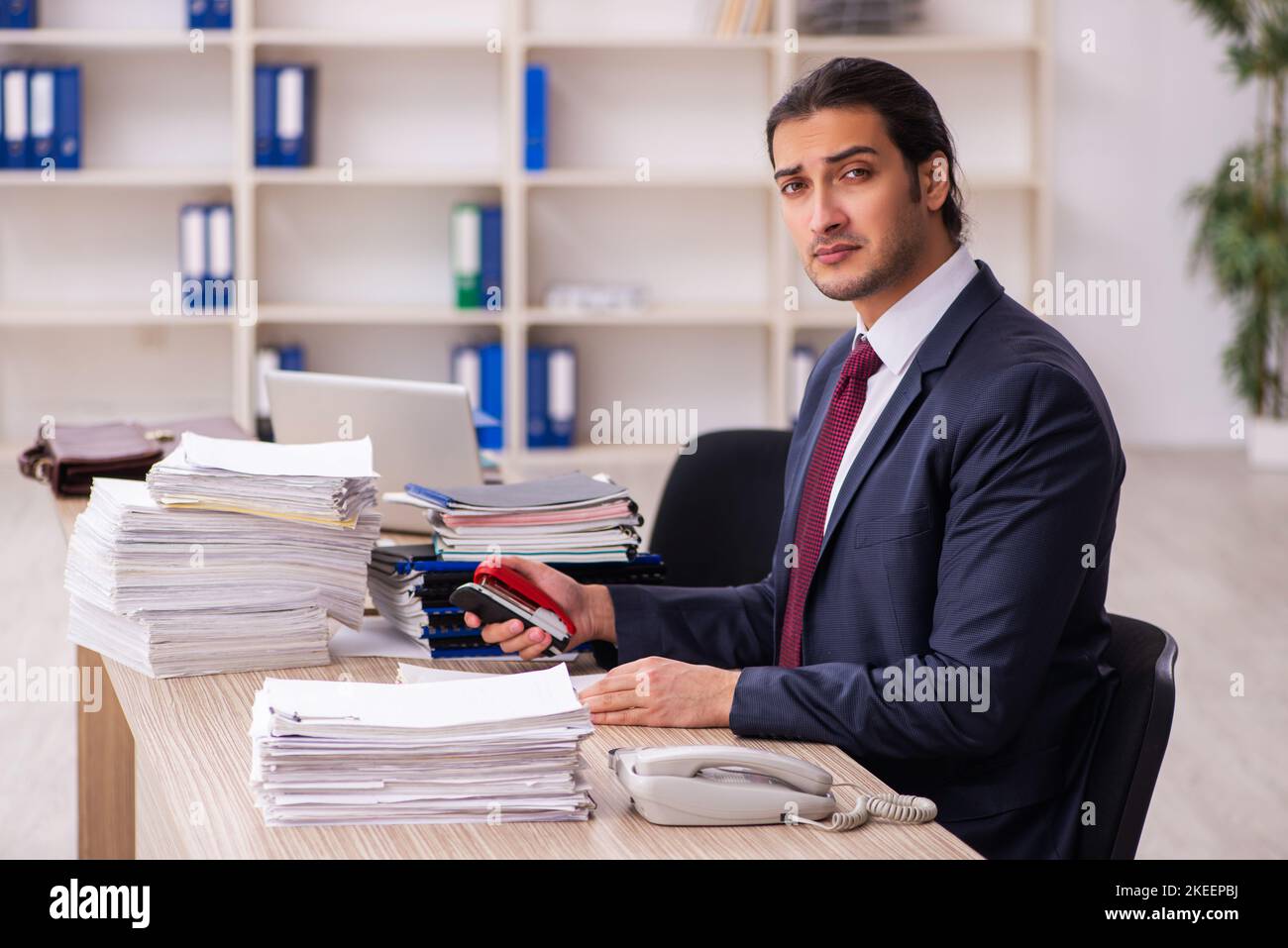 Young businessman employee unhappy with excessive work Stock Photo