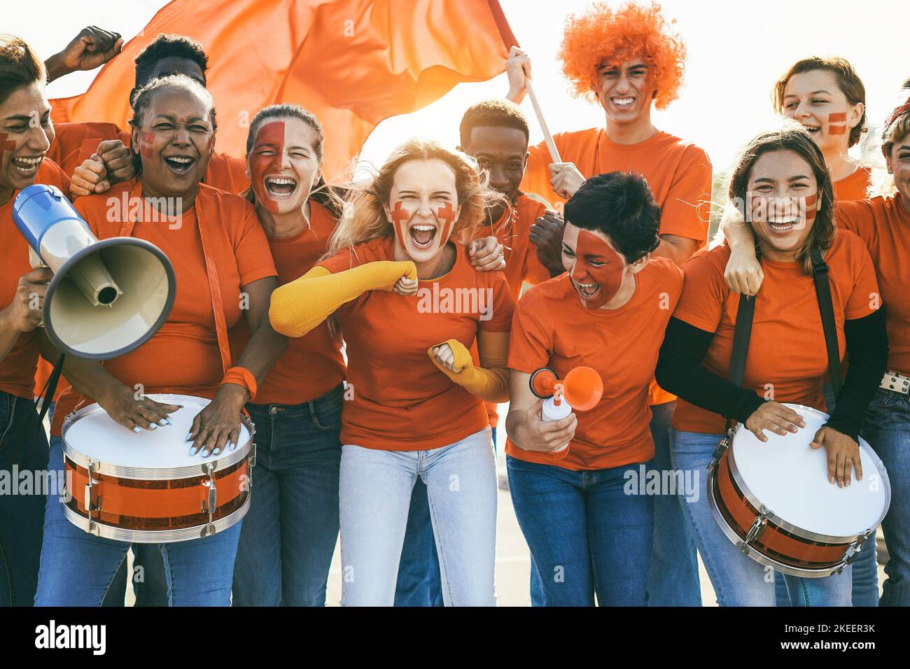 Multiracial sport fans screaming while supporting their team - Football supporters having fun at competition event - Focus on center girl face Stock Photo