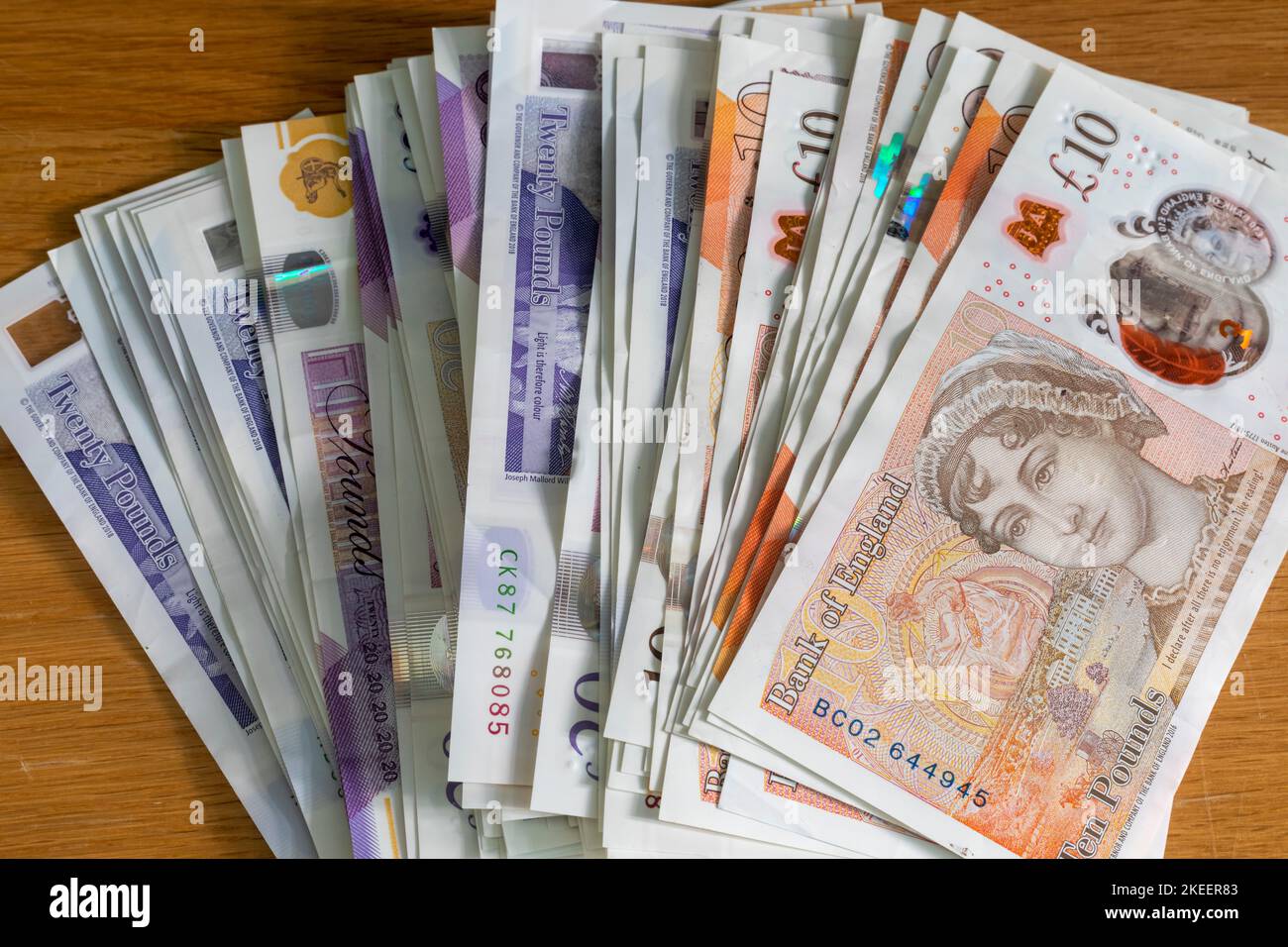 A pile of British £20 and £10 pound notes laid out on a table Stock ...