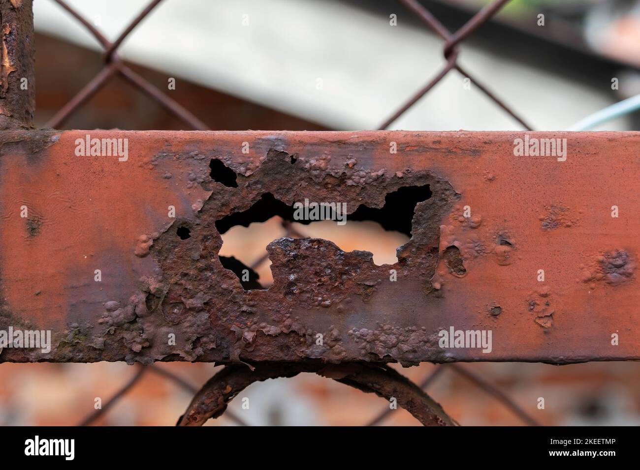 Rusty metal fencing partially destroyed by corrosion. Stock Photo