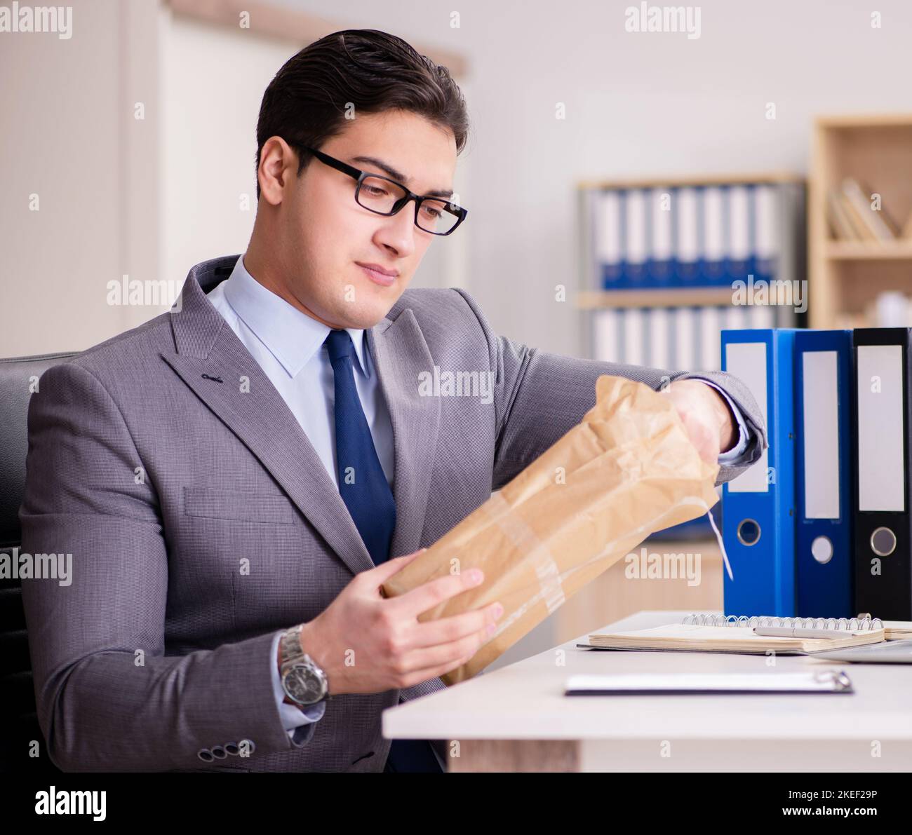 The businessman receiving parcel in the office Stock Photo - Alamy
