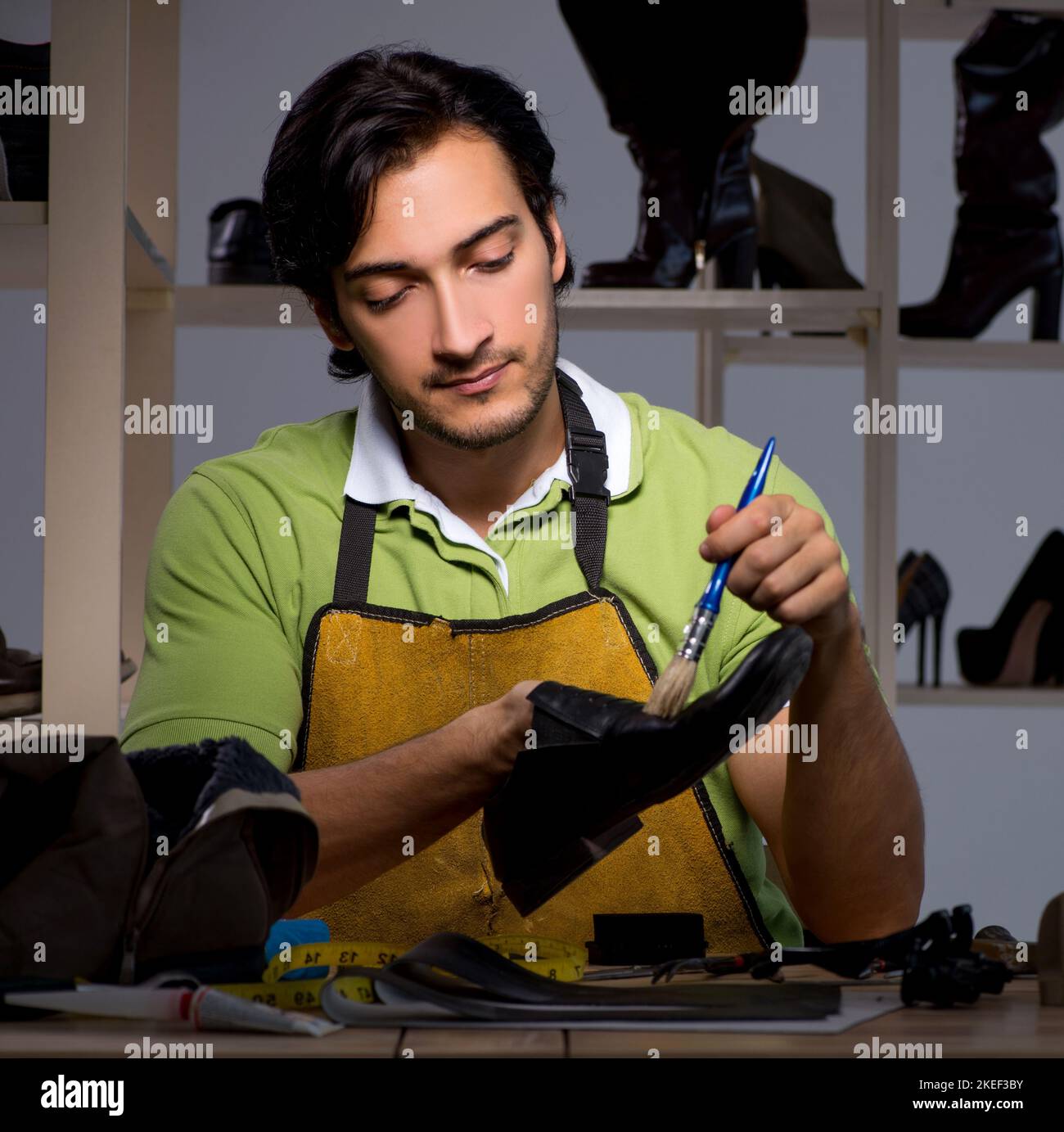The young shoemaker in workshop at night Stock Photo - Alamy