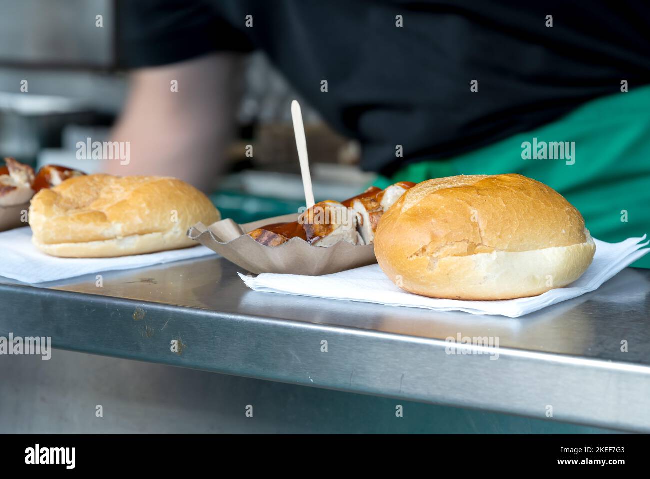 Currywurst with buns on the counter of a stall. Currywurst, grilled sausage cut into pieces with curry powder and ketchup sauce Stock Photo