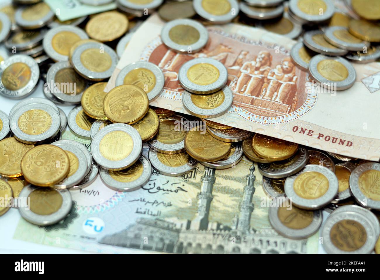 pile of Egyptian money banknotes and coins of 1 EGP LE one Egyptian pound and half a pound 50 fifty piasters, stacks of Egypt currency background, eco Stock Photo