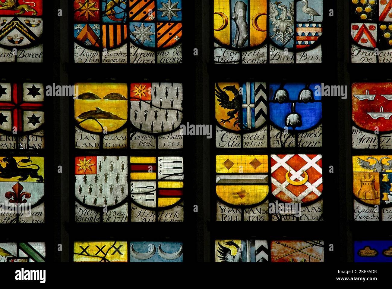Amsterdam’s early-18th century civic leaders are commemorated by these colourful heraldic stained glass shields in a window in the Dutch city’s earliest building, the Oude Kerk or Old Church in Ouderkerksplein.  Mayors or burgemeesters from 1578 to 1757 are recorded in this window, while a second window features the arms of their successors from 1757 to 1795, plus some early 1800s aldermen. Stock Photo