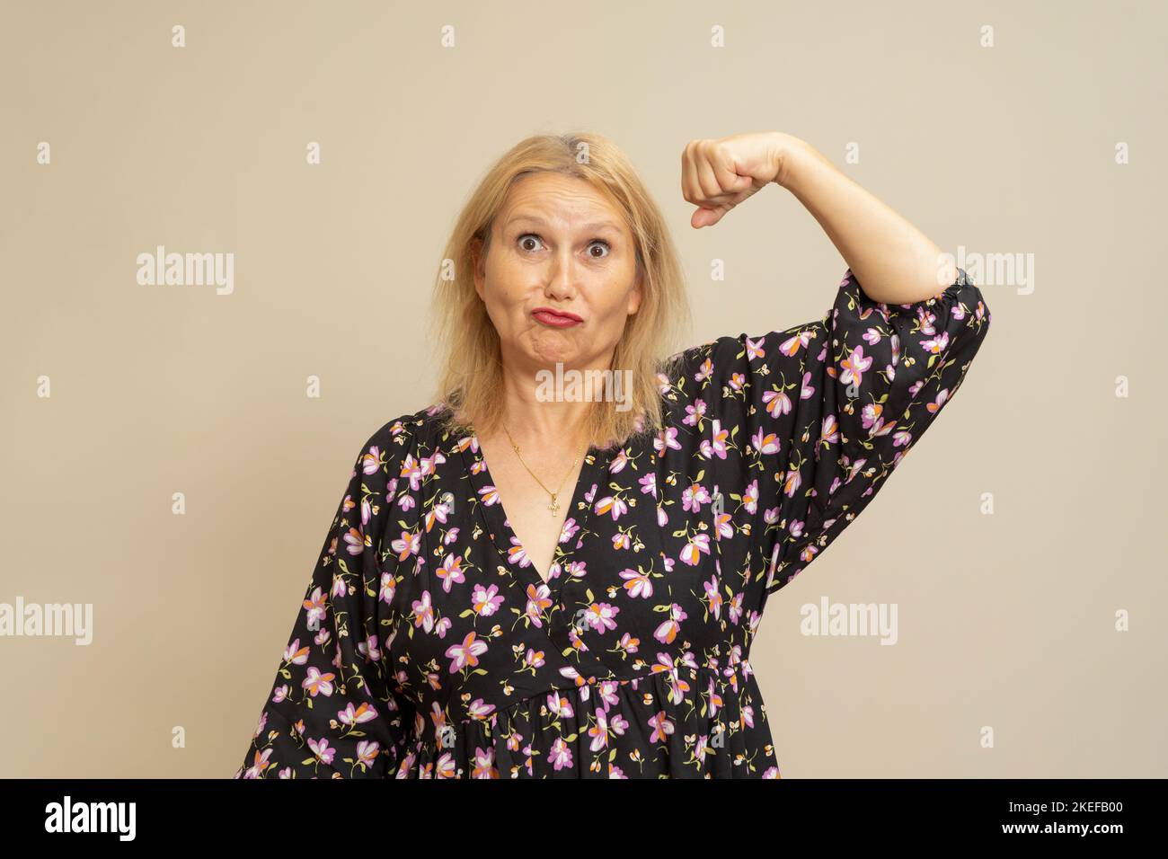 Sport, healthy lifestyle, fitness, good body condition, women's health. Close up portrait of a blonde woman smiling while showing off her arm and Stock Photo