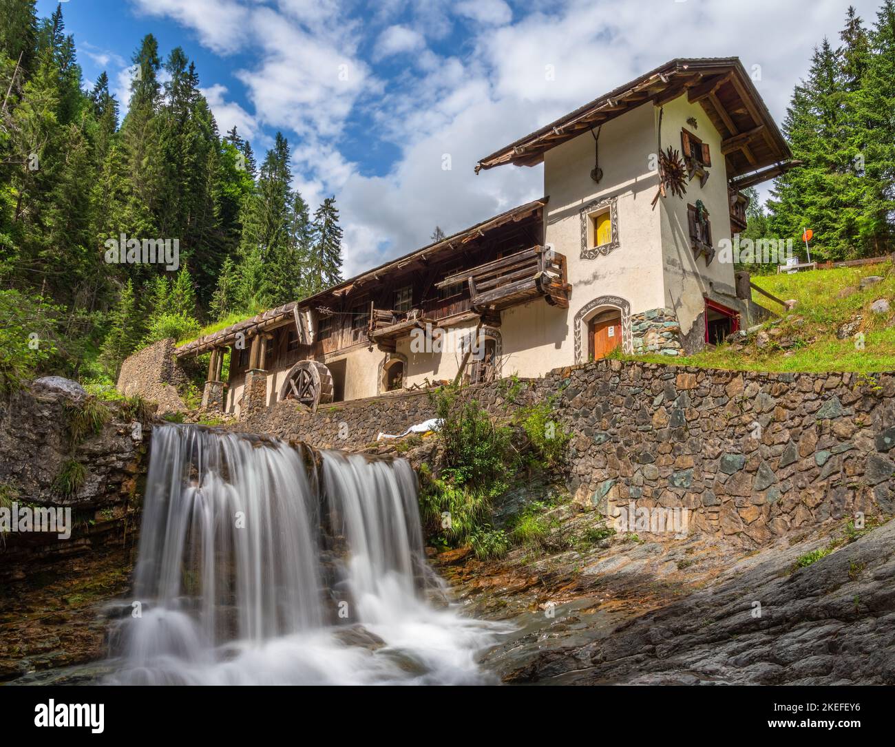 Sappada, Italy - July 27, 2022: Idyllic abandoned water mill in Sappada, an alpine village on the edge of the Italian Dolomites Stock Photo