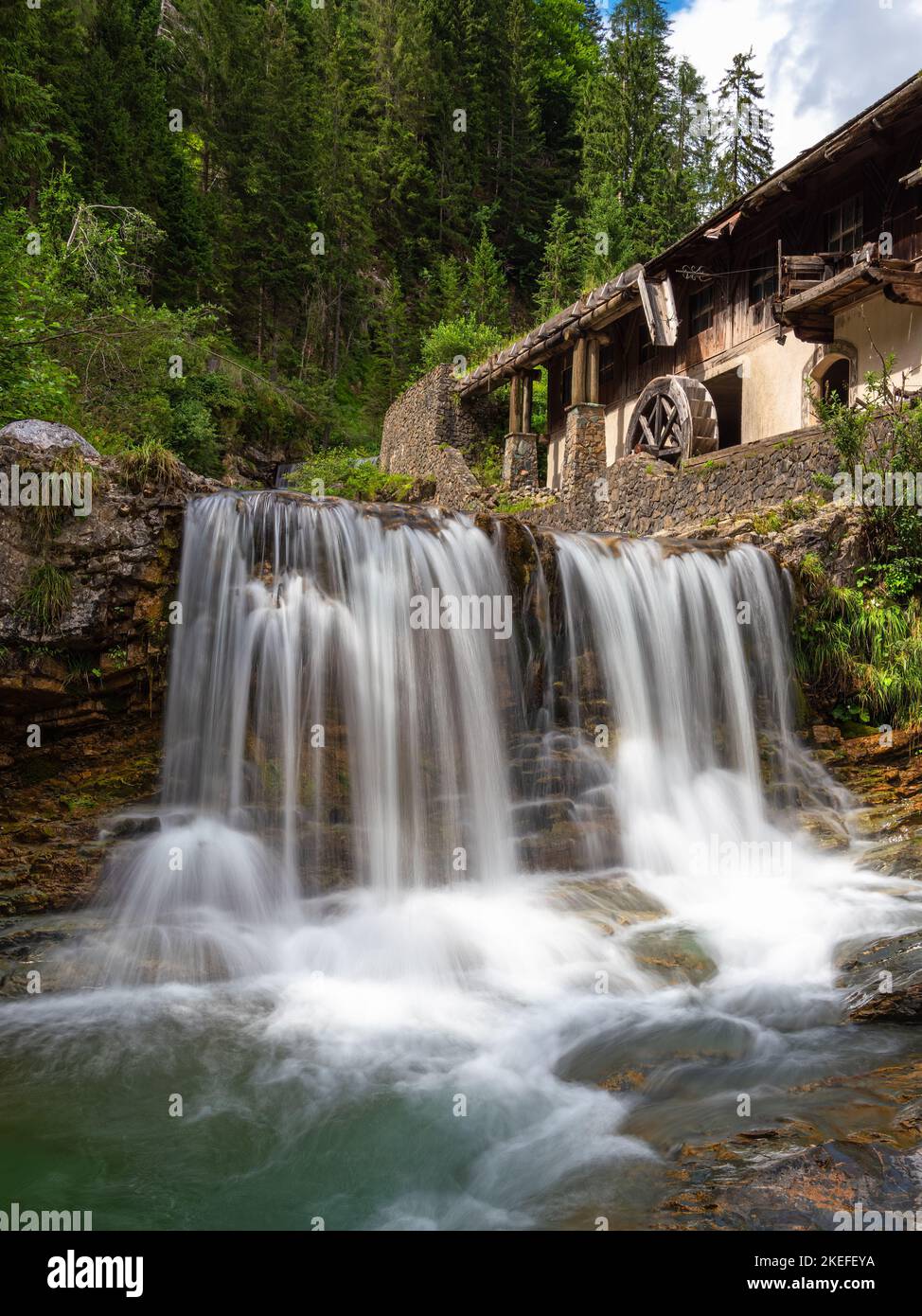 Waterfall and abandoned water mill in Sappada, an alpine village on the edge of the Italian Dolomites Stock Photo