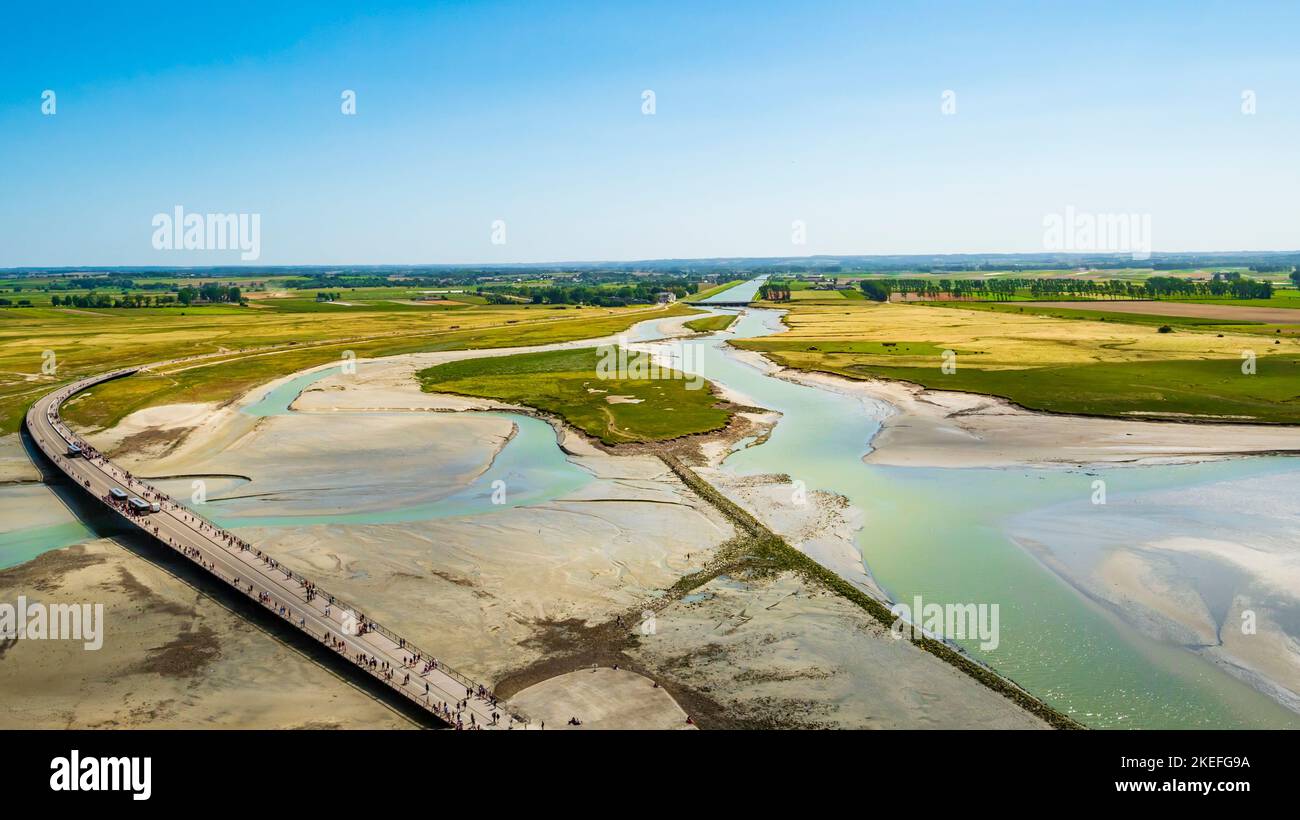 Stunning aerial view of the road and the colourful sand flats surrounding Le Mont Saint Michel during low tide, Normandy, Northern France Stock Photo
