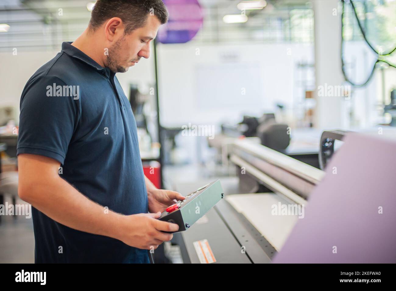 In the printing house, an experienced technician works on a UV printer. Production work. Check