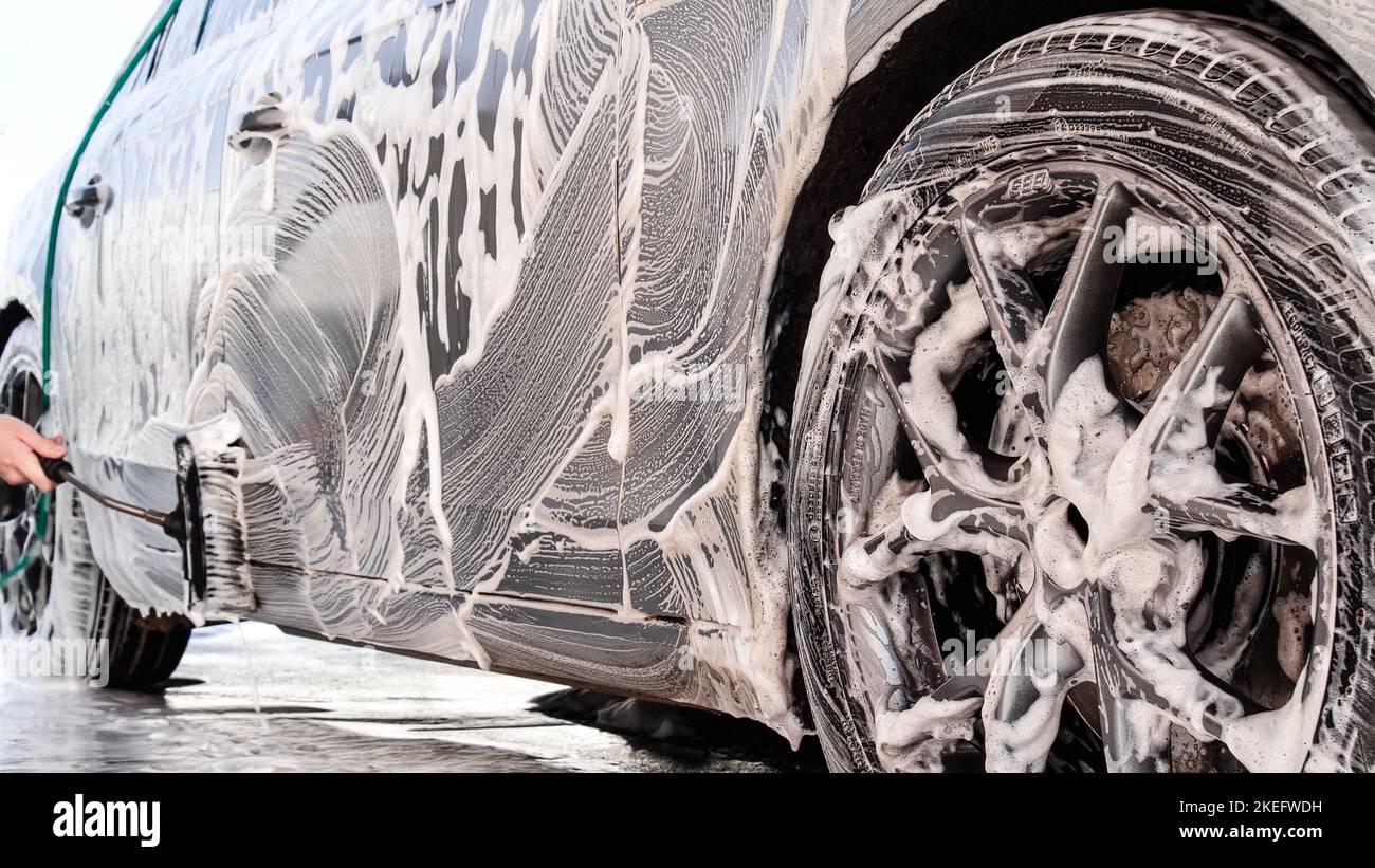 Washing luxury car on a touchless car wash. Washing sedan car with foam