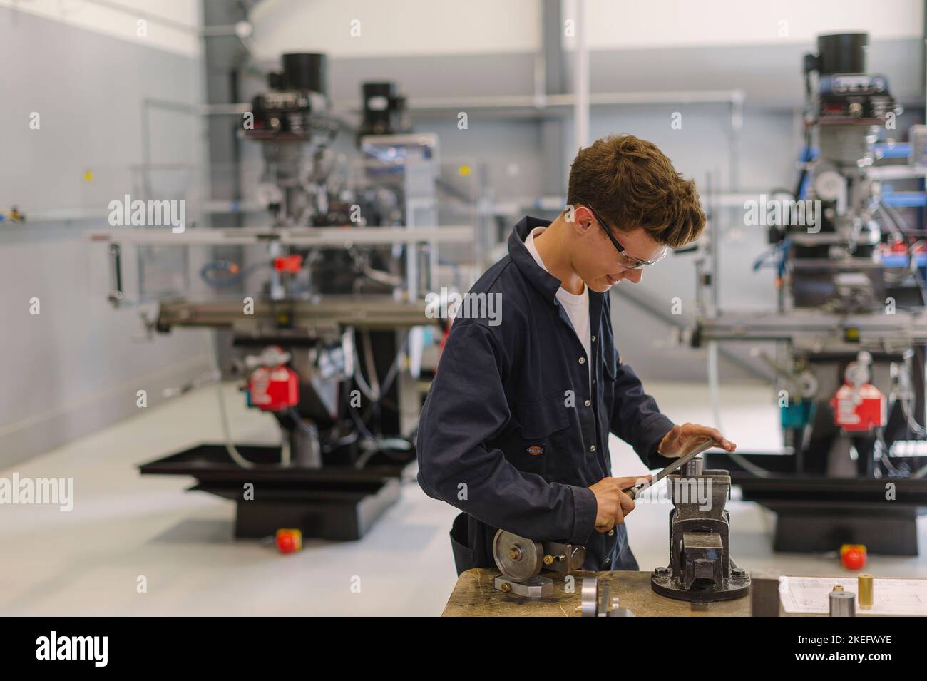 An Engineering student using tools in an engineering centre, college, university. Stock Photo