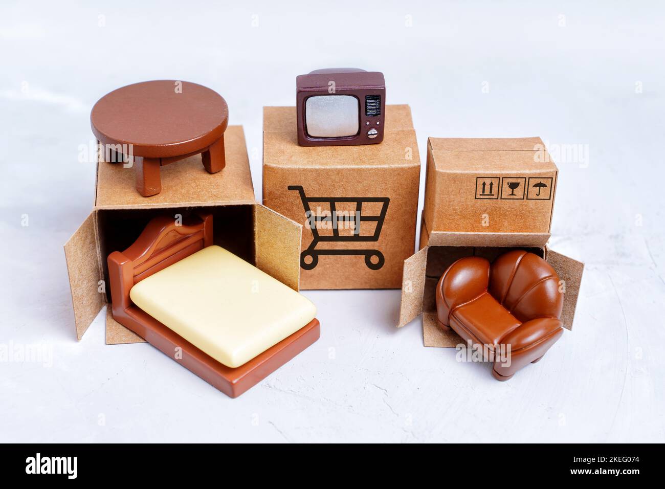 Tiny shipping boxes and miniature furniture figurines isolated on gray