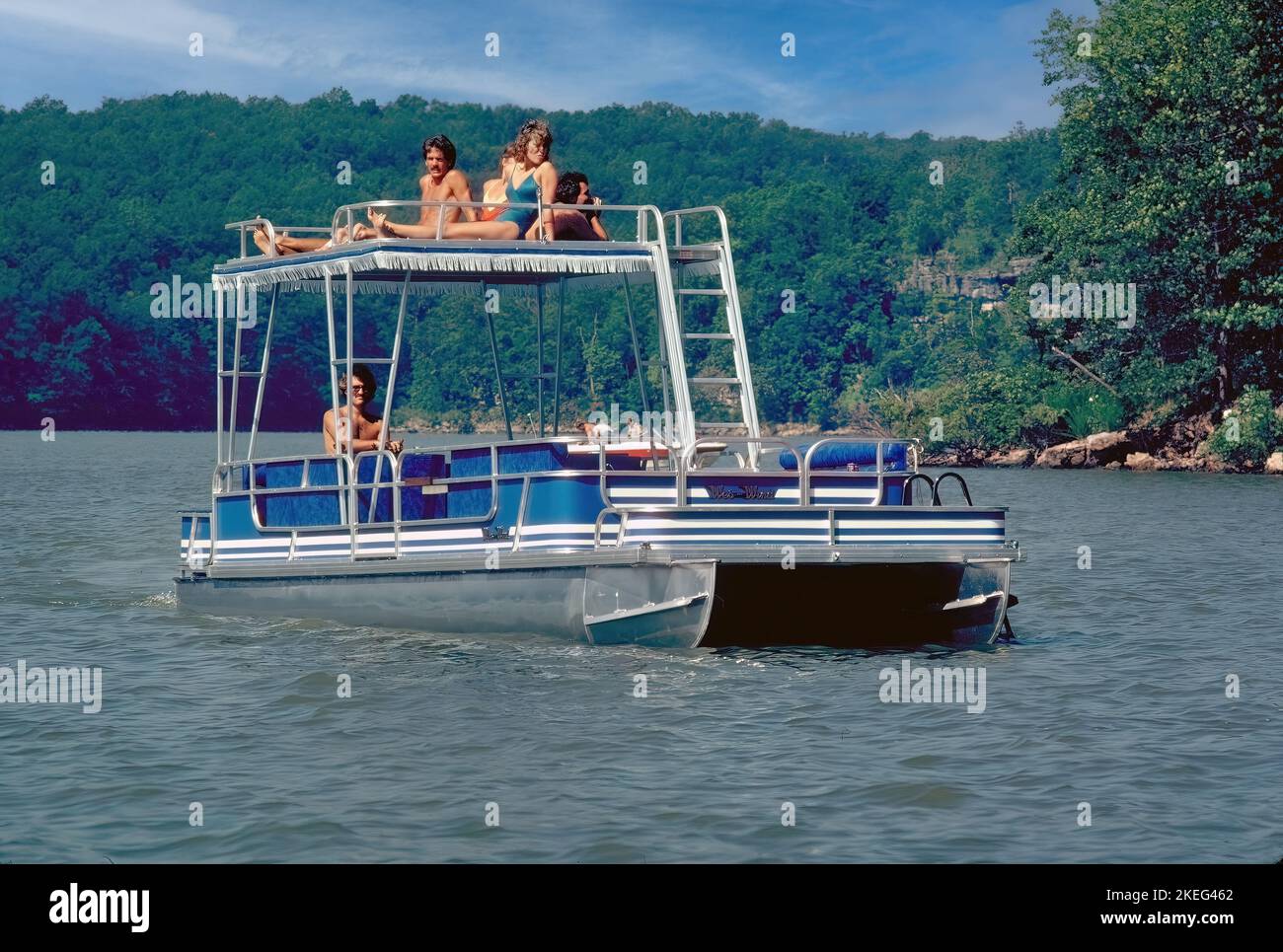 Passengers on a pontoon boat sun on the sundeck as it glides along on Lake of the Ozarks in Missouri. Stock Photo