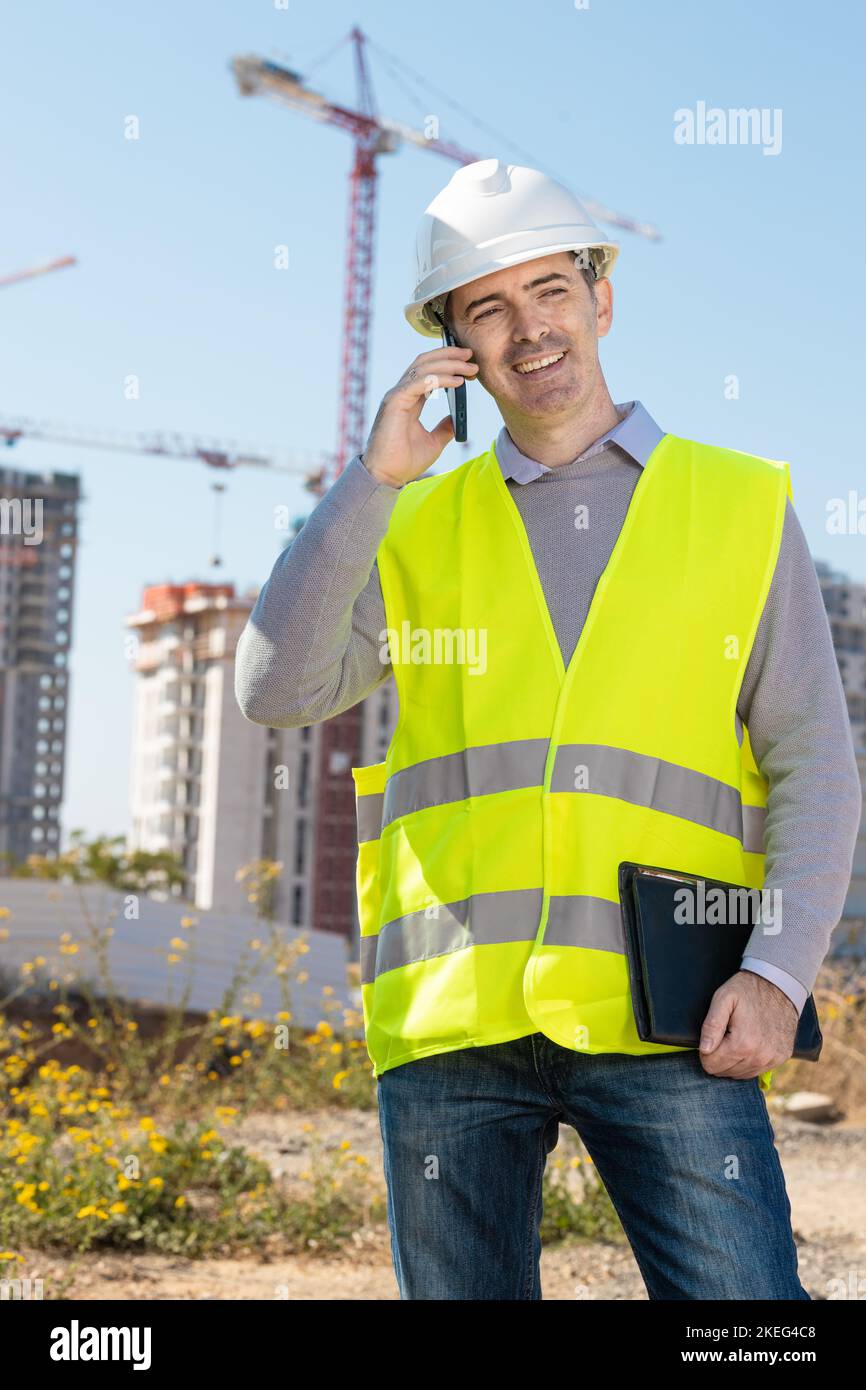 Professional builder standing with a notebook in front of the ...