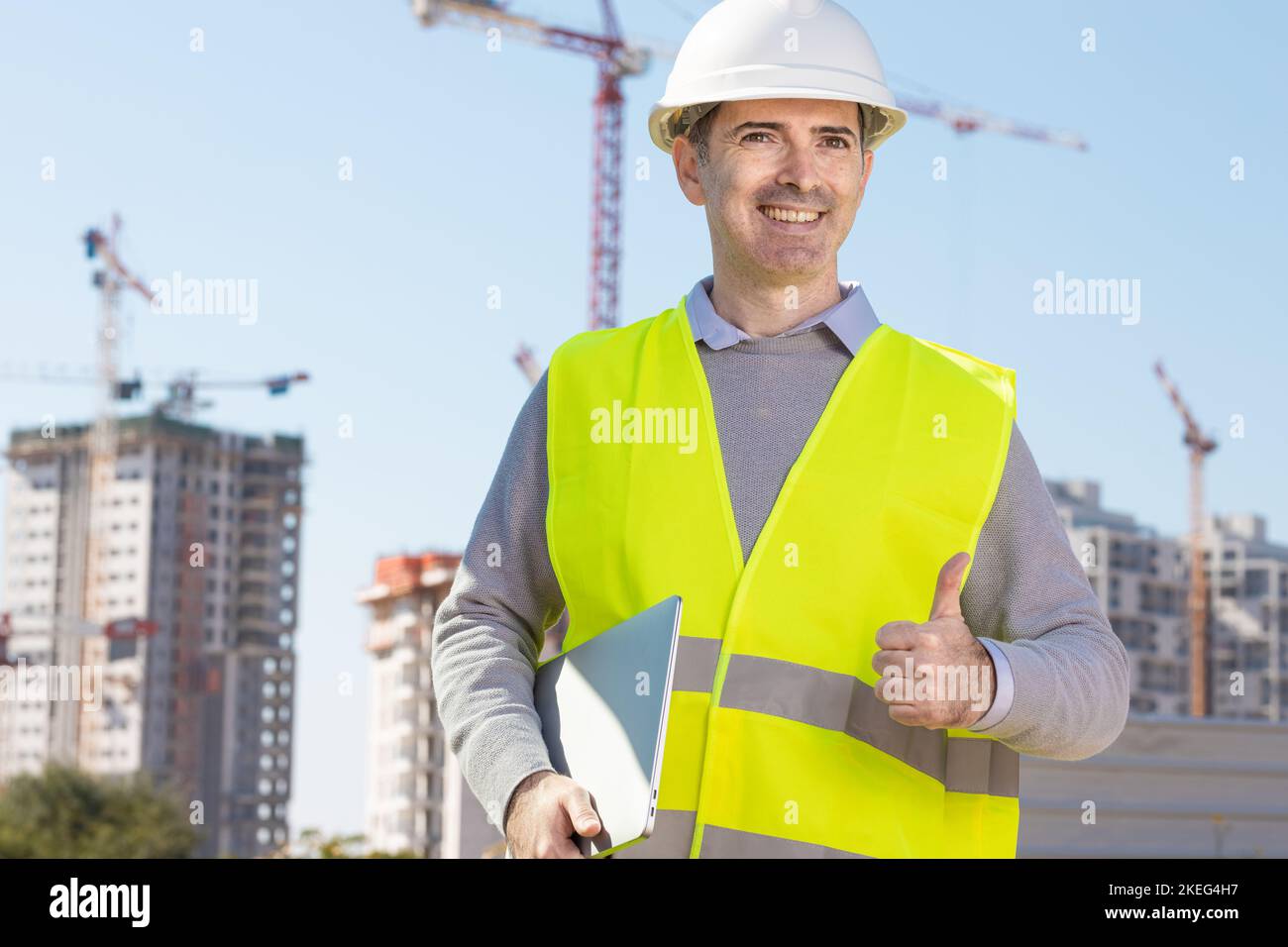 Professional builder standing with notebook in front of the ...