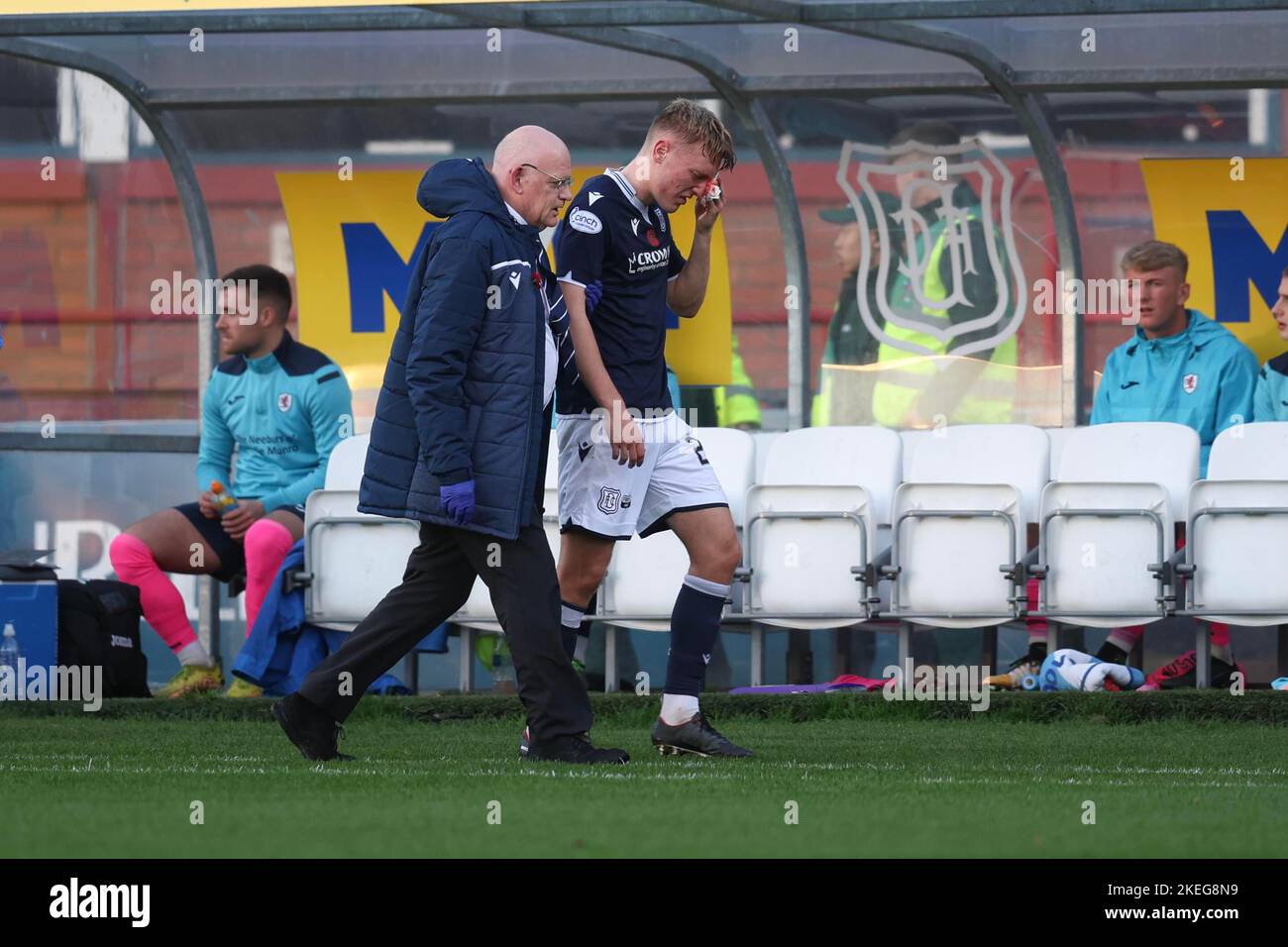 Dundee, Scotland, UK. 12th November 2022;  Dens Park, Dundee, Scotland: Scottish Championship football, Dundee versus Raith Rovers; Max Anderson of Dundee goes off with the club doctor to get stitches in a head wound Credit: Action Plus Sports Images/Alamy Live News Stock Photo