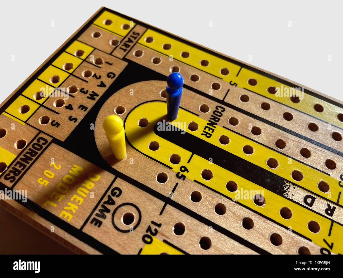 Wood Cribbage Board with Blue and Yellow Pegs Stock Photo