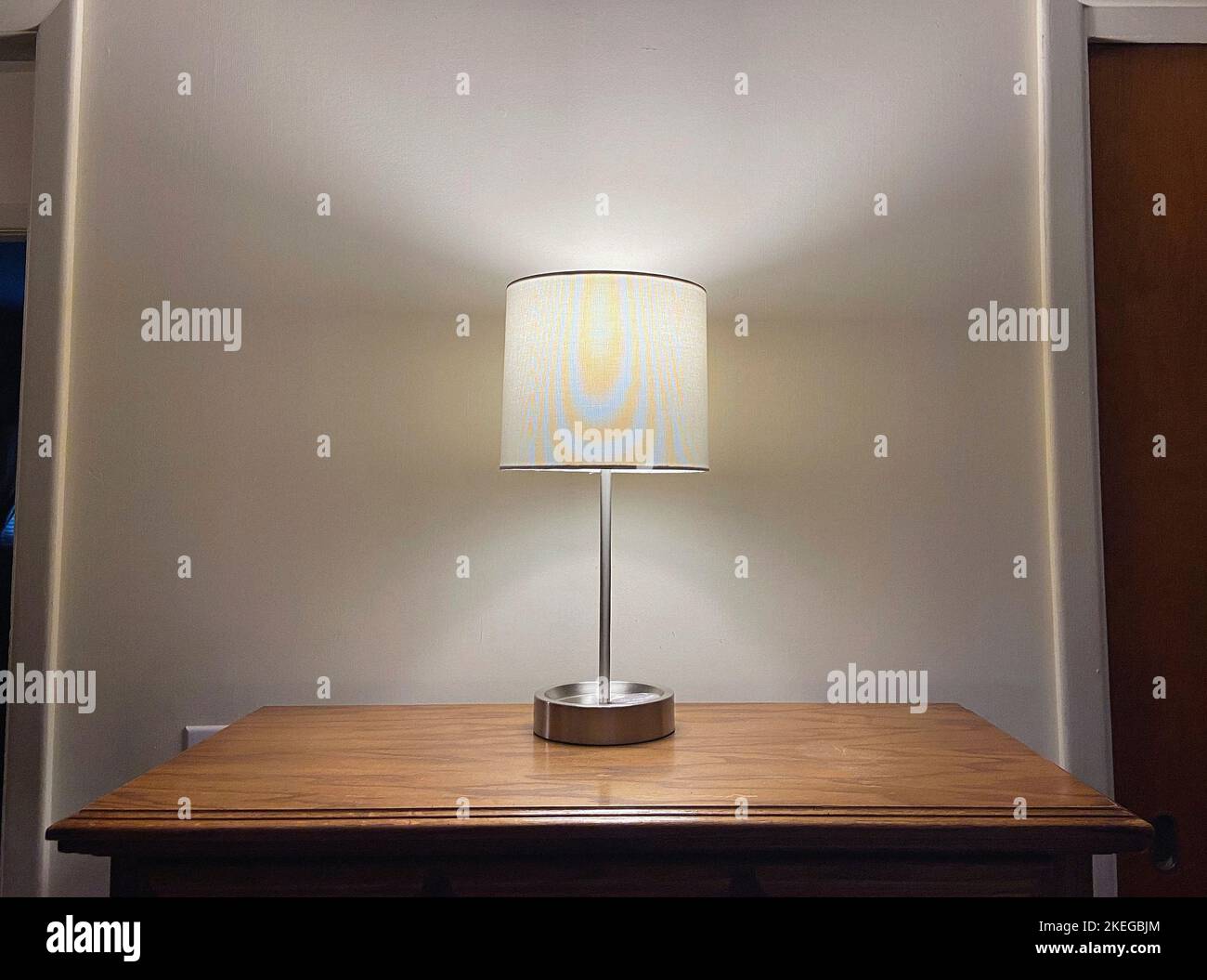 Illuminated Table Lamp on Wood Dresser Stock Photo Alamy