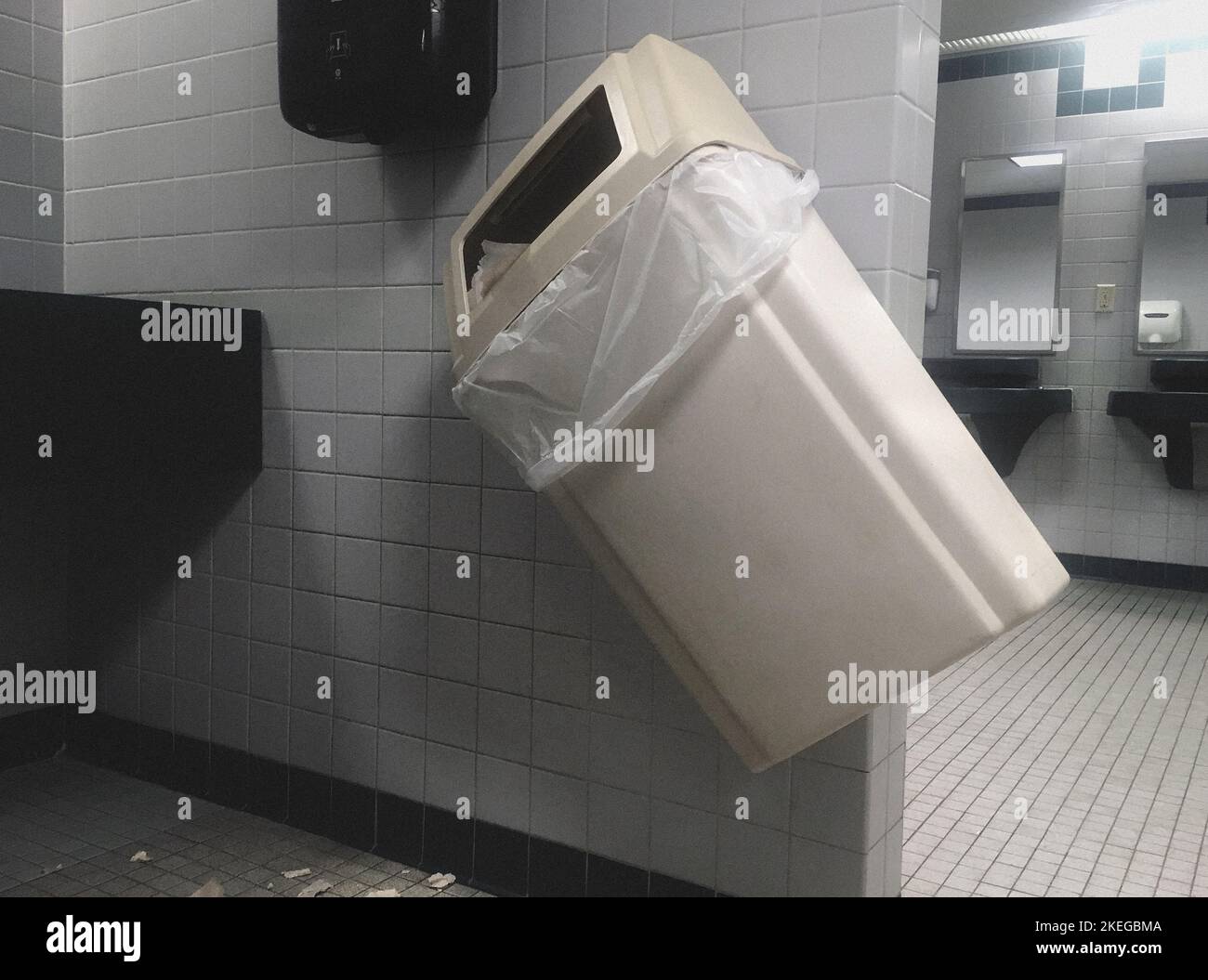 WallMounted Garbage Pail knocked on Angle in Public Bathroom Stock