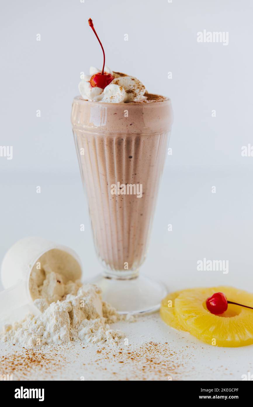 a Vertical closeup shot of a glass of Chocolate Protein Shake with ...