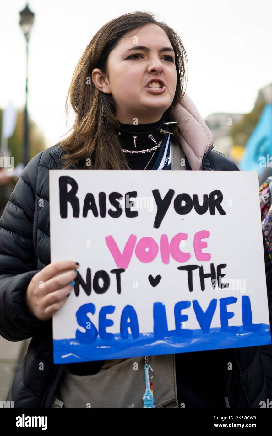 CARDIFF, WALES - NOVEMBER 12: A woman holds a sign saying “raise your voice not the sea level” during a protest for climate justice on November 12, 20 Stock Photo