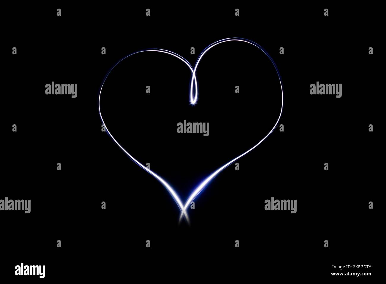 Light heart symbol on isloted black background. Long exposure creative