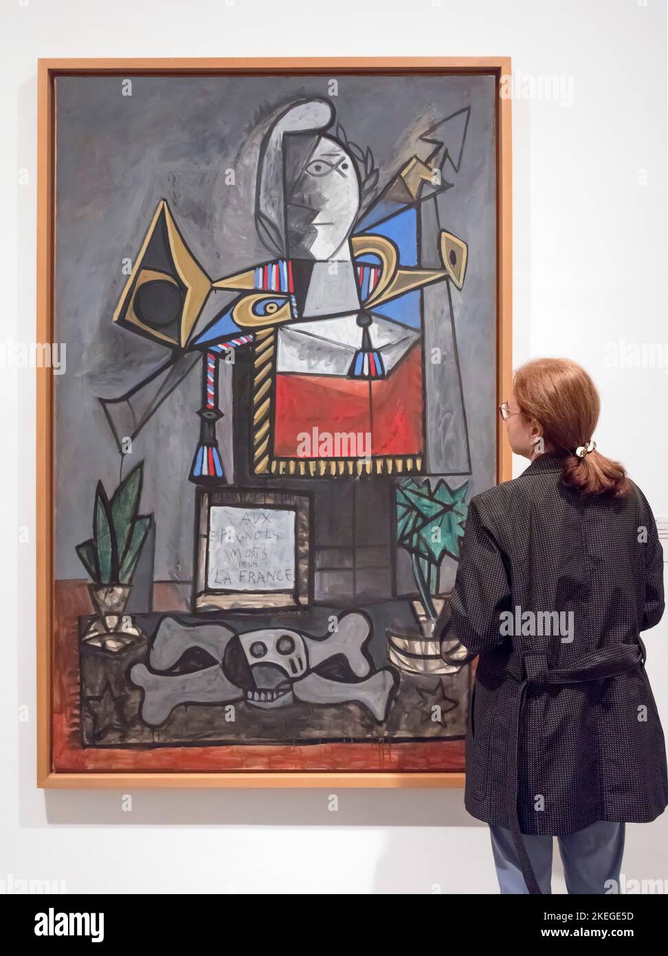 A woman looks at Pablo Picasso's painting Monument to Monument aux espagnols morts pour la France (Monument to Spaniards Who Died for France) 1946-47 Stock Photo