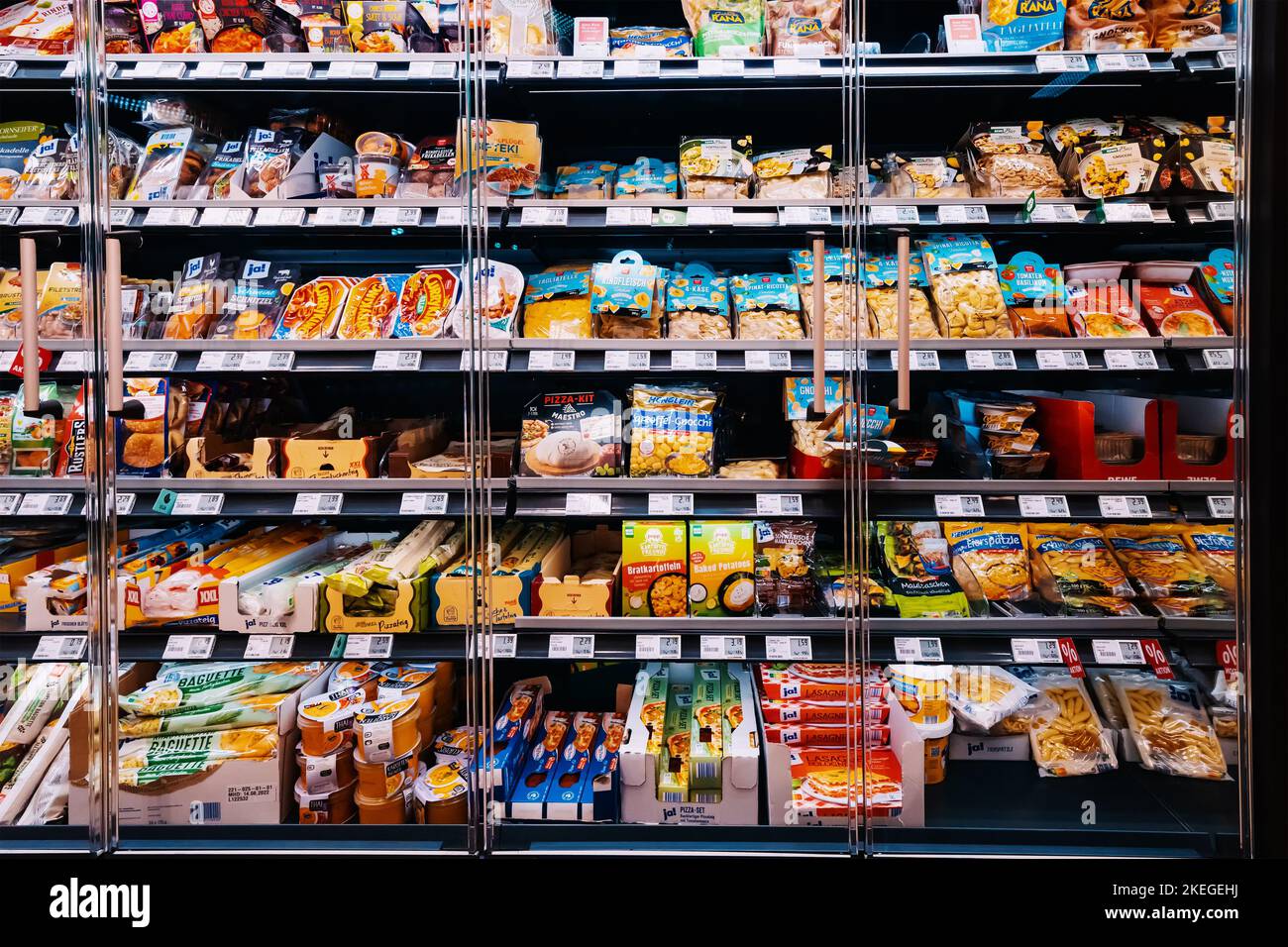 25 July 2022, Munster, Germany: Various goods and food on the shelf of a fridge in supermarket or grocery store Stock Photo