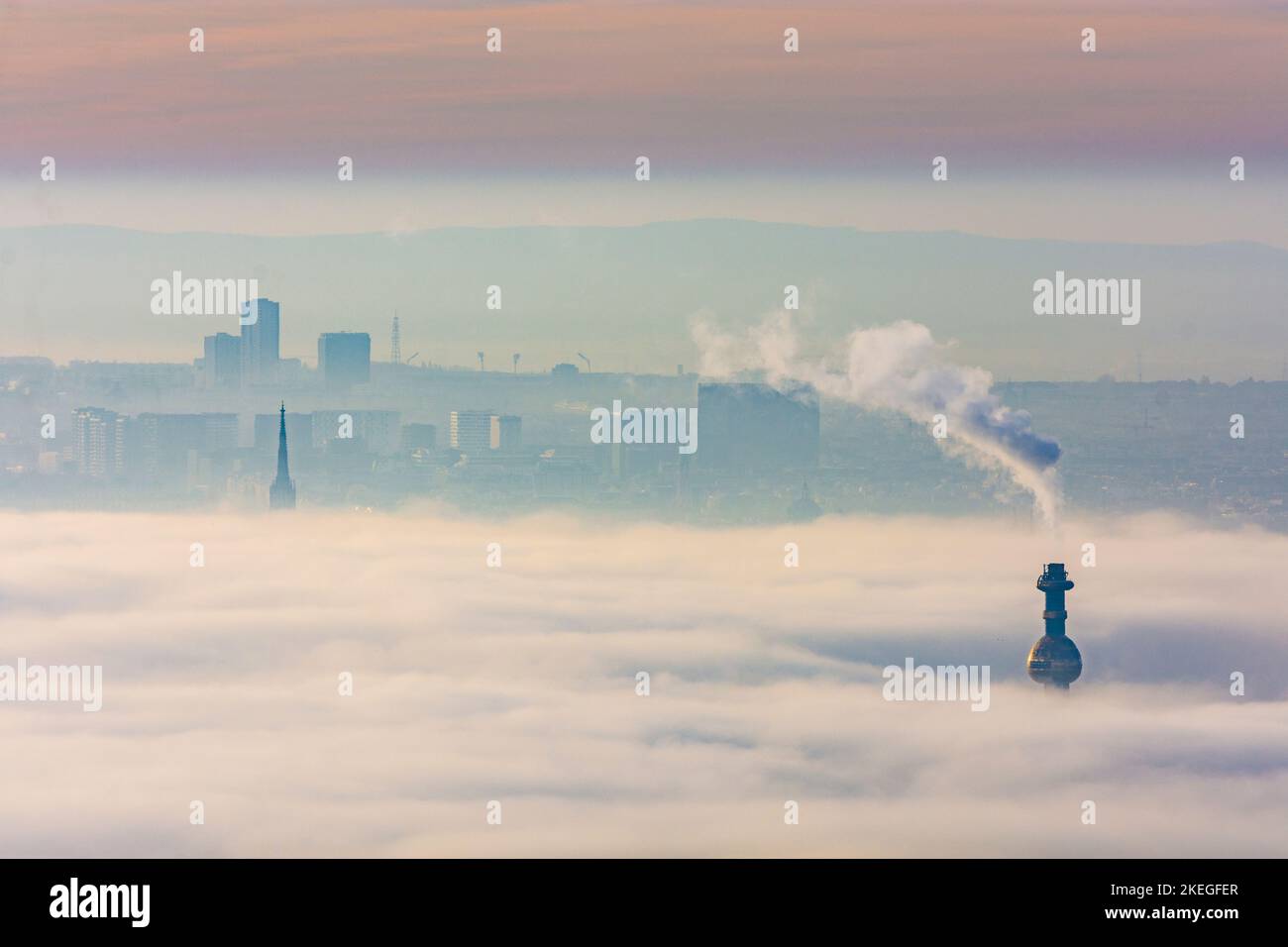 Wien, Vienna: towers stick out from ground fog, steeple of Stephansdom (St. Stephen's Cathedral), chimney of Spittelau waste incineration plant mornin Stock Photo