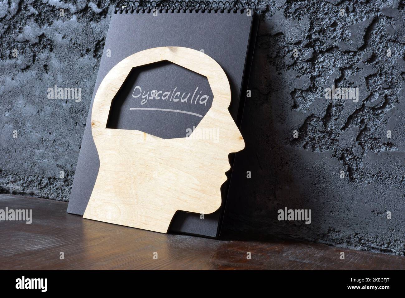 Handwritten word dyscalculia and wooden head shape. Stock Photo
