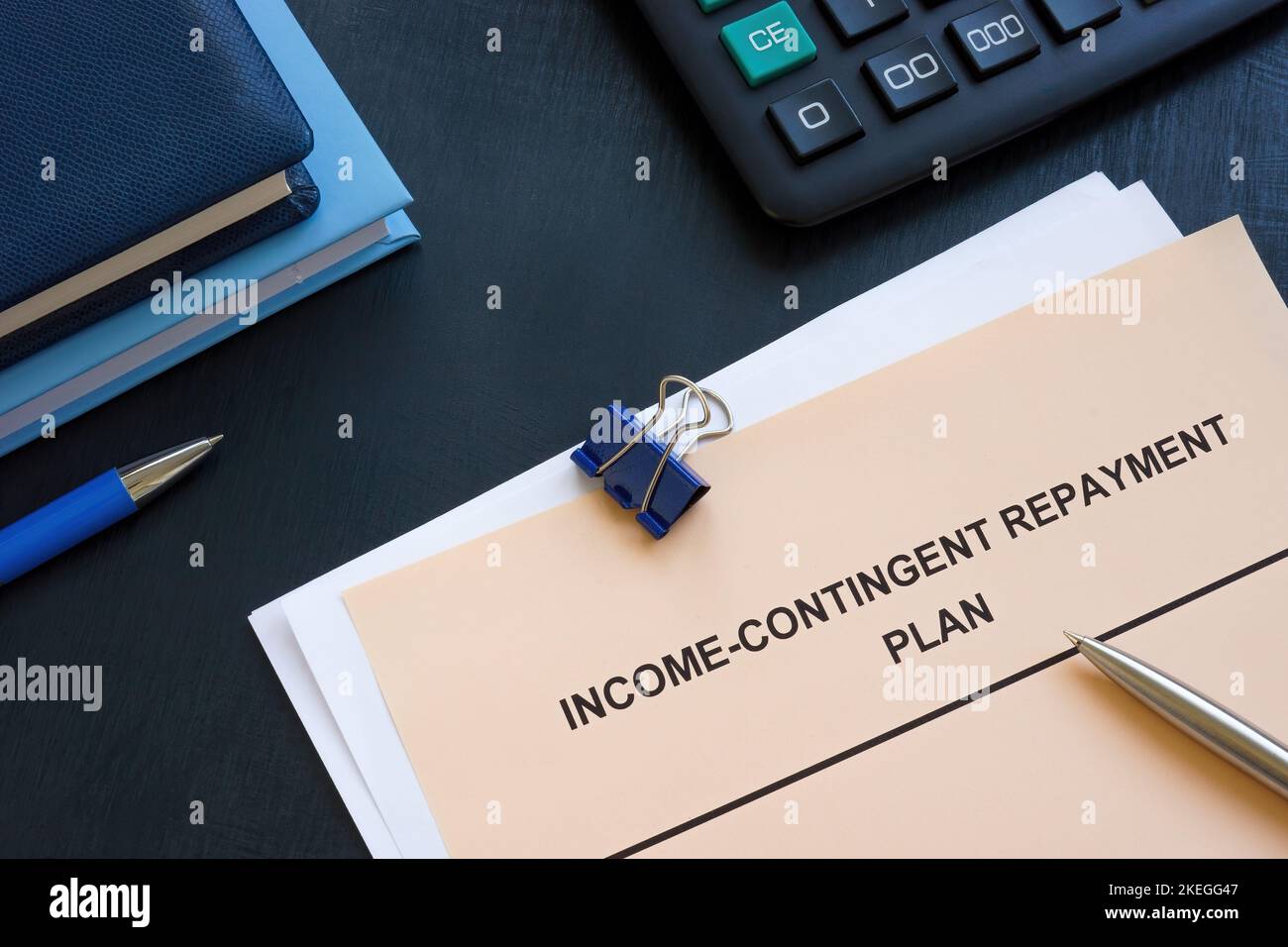 Income contingent repayment plan near calculator and notepads. Stock Photo