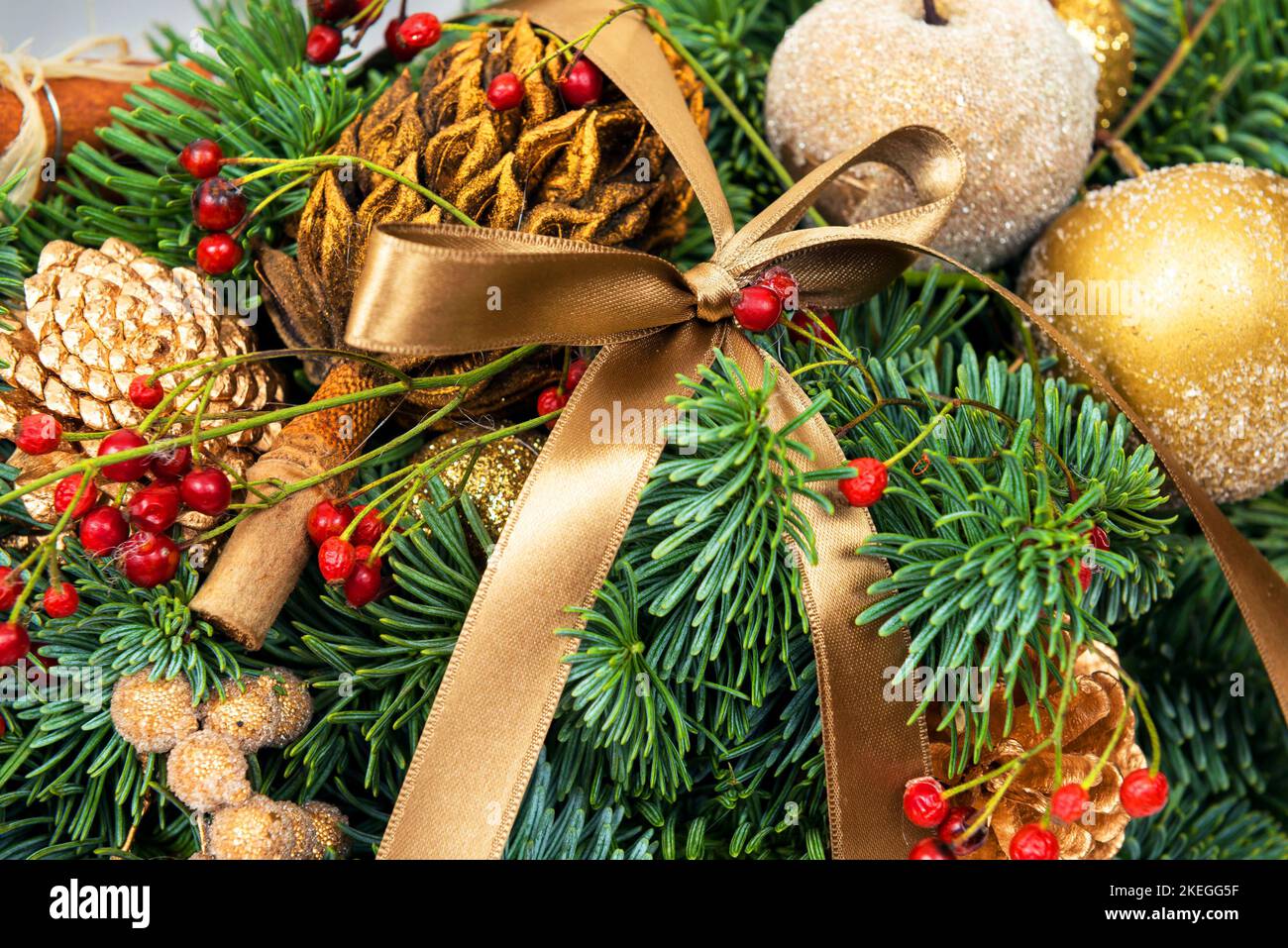 Christmas holiday decorations, festive composition with natural pine branches and cones, ribbon and baubles. Beautiful luxury handmade ornament close- Stock Photo