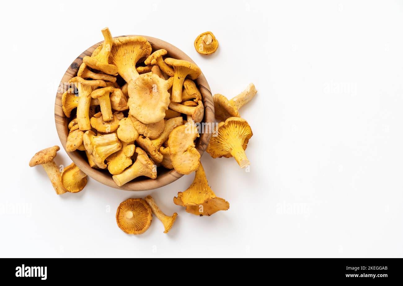 Wooden bowl full of chanterelle mushrooms on white background Stock