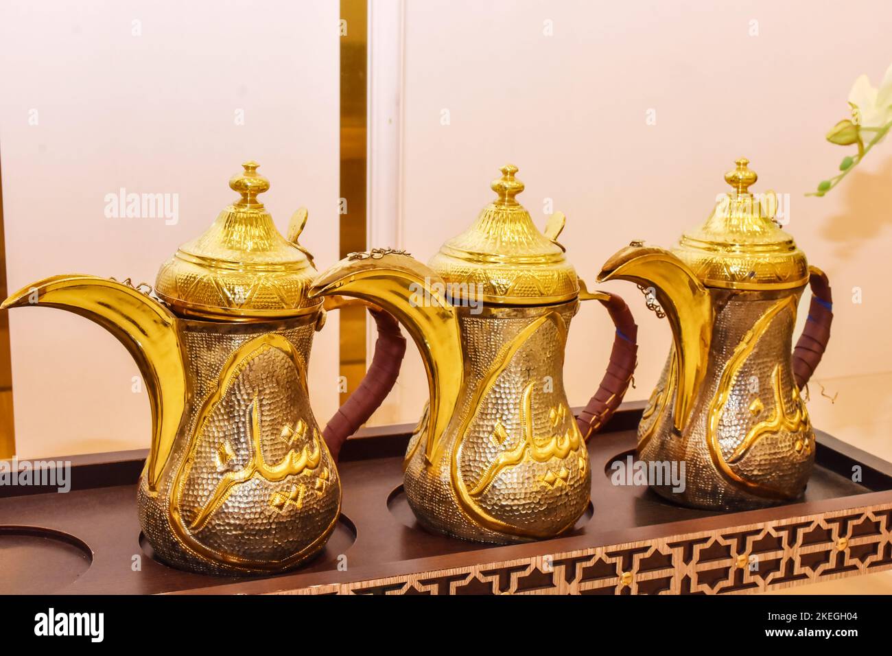 closeup of arabian cultural coffeepot ( dalla ) set of three luxury golden metallic caffeine arabic traditional tea qahwa jar muslims hospitality uten Stock Photo