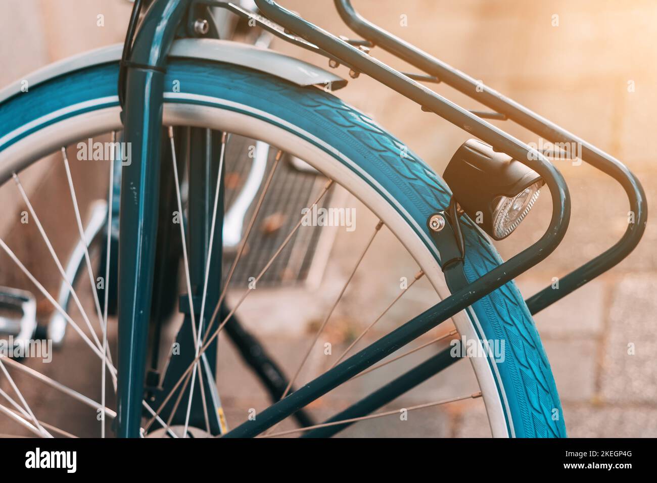 Detailed view of a retro vintage bicycle used for town transportation with blue tyre and iron trunk and flashlight Stock Photo